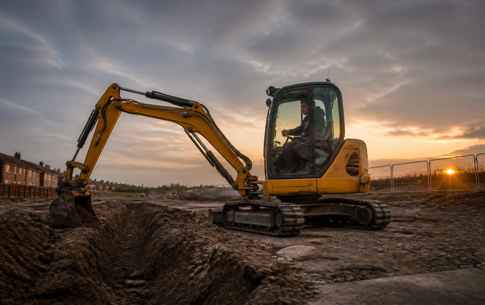 Tracked mini excavator digging a trench on a groundwork site in Warwickshire